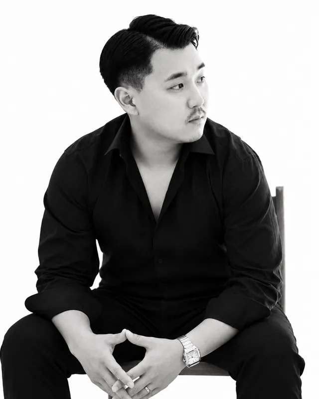 Tae Joon Kim, Partner of JKM Architecture, seated and looking to the right in a black-and-white portrait